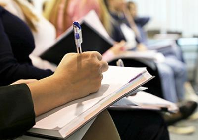 Person writing on a notepad with a pen